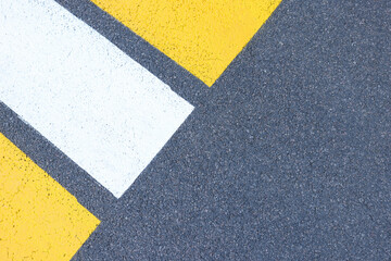 Pedestrian crossing with yellow-white stripes on road surface