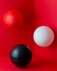White, red, black balls on a red background. Abstract composition. Design.