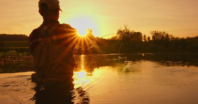 Fly fishing. Fly fisherman casts the line on the river. Angler stands in the river and casts the fly