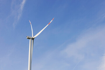 Windmill for electric power production against the blue sky.