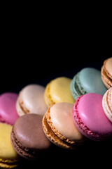 macaroons of different colors on a black background