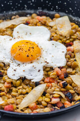 lentils with smoked meat and onion served with fried egg