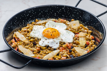 lentils with smoked meat and onion served with fried egg