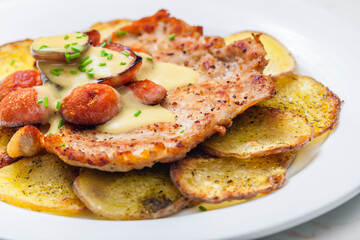 roasted pork meat with sausage, mustard sauce and roasted potatoes