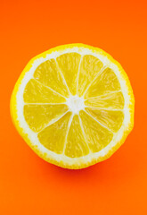 Fototapeta na wymiar Close up photo of lemon texture on the orange background. Fruit cut in half, inside, macro view. Beautiful natural wallpaper.