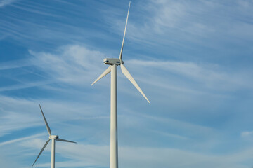 Windmill turbine propeller against blue sky. Natural green energy conservation concept