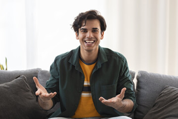 Smiling caucasian man sit at home have pleasant web conference on computer, happy millennial male...