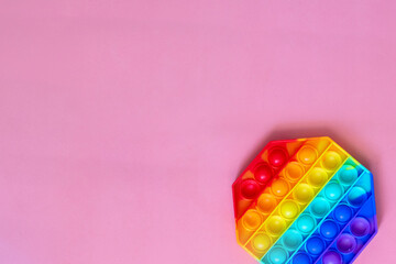 the rainbow-colored pop toy lies on the background. space for text