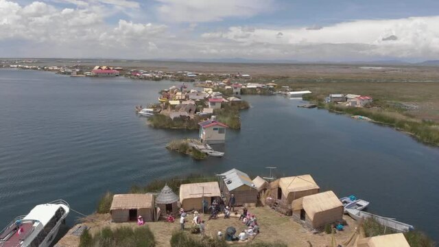 Aerial: Tourists on guided tour experience Uros Floating Islands, Peru