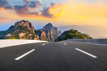 Asphalt highway and mountain landscape at sunset,road pavement background.