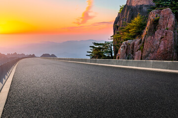 Asphalt highway and mountain landscape at sunset,road pavement background.