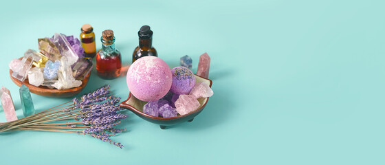 Gemstones minerals, lavender, Spa treatments - oil bottles, bath bomb on green-blue background. Crystal ritual, spiritual practice, body care. Wiccan Witchcraft. banner