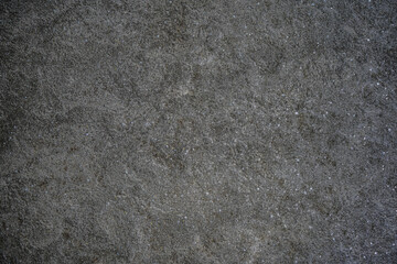 Grungy stone texture background. Dark wall texture of granite found on floor, wall, cement construction decorative. Rough and cracked surface.