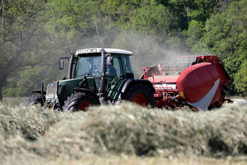 landwirtschaftliche nutzmaschine traktor bei der heuernte auf einer wiese © Sigtrix