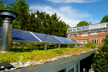 Solar panels on a green roof with flowering sedum plants. Sedum rooftop garden with photovoltaic cells for sustainable energy.