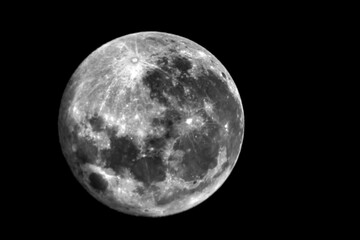 Full moon and craters taken with a telephoto lens. black and white photo.
