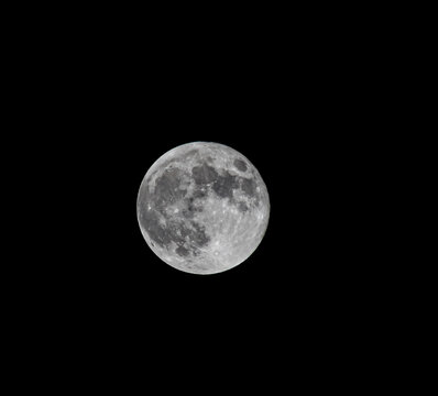 Full moon and craters taken with a telephoto lens. black and white photo.