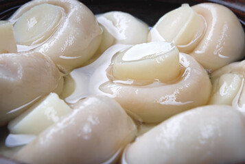 Background from small pickled champignons. Pickled mushrooms.