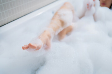 Fototapeta premium Woman's feet bathe in the bathtub