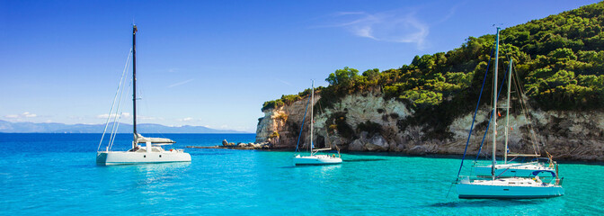 Beautiful bay with sailing boats, Paxos island, Greece. Panoramic view, banner