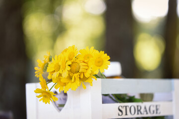 Wooden box with yellow wild flowers. Text storage