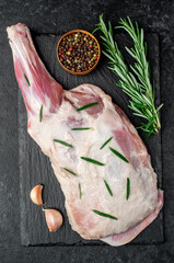  raw lamb shoulder blade with rosemary on stone background