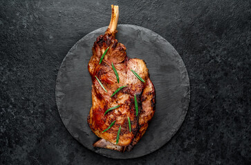Baked lamb, sheep leg with rosemary. Stone background