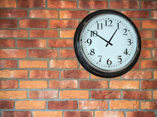 Wall clock on a red brick wall.