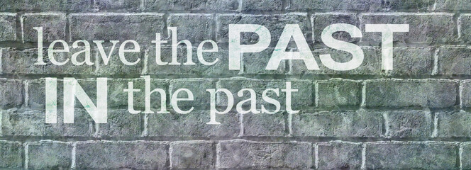 Wise words LEAVE THE PAST IN THE PAST message banner  - grey rustic brick wall background with words of wisdom leave the past in the past and space for copy
