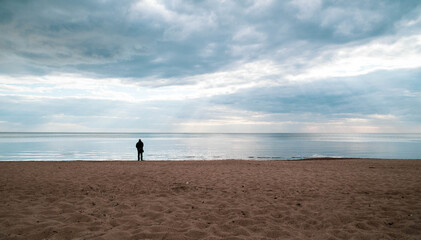 The man stands by the sea, looks into the distance and thinks about his life.
