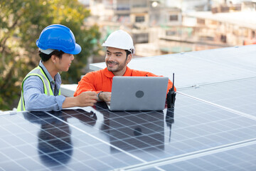 engineers or technicians talking about project with laptop computer and checking solar panels on the top of the roof