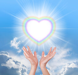 Sending you beautiful healing energy  across the ether - female hands sendign out rainbow heart...