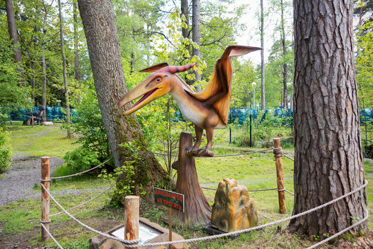 Moving figure of pterodactyl in dinosaur park in Zelenogorsk on a sunny summer day. The inscription - do not touch the dinosaurs on the planch. - Saint Petersburg, Russia, May 2021.