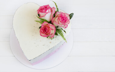 Heart shape cake decorated of pink roses. Concept for Wedding , St. Valentine's Day, Mother's Day, Birthday Cake. White background