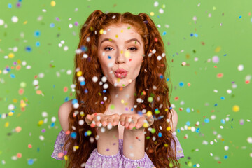 Photo of cute red hairstyle young lady blow kiss confetti wear blouse isolated on green color background