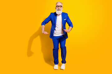 Fototapeta na wymiar Full length photo of funky funny happy old man dance good mood smile wear shoes isolated on yellow color background