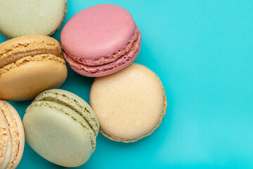 French biscuit biscuits in different colors. Macarons, closeup, studio shot, dark blue background.