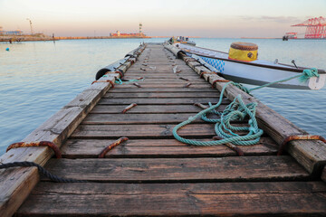 Obraz premium Wooden pier with blue sea. Wood floor or terrace beside the blue crystal clear sea, boat and a rope.