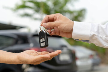 selling car, car sale, deal concept The dealer gives the car keys to the new owner or renter with...