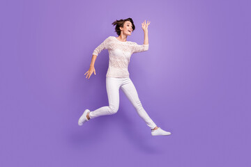 Full length photo of sweet pretty young woman wear knitted shirt jumping high isolated violet color background