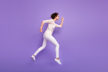 Fototapeta na wymiar Full length photo of charming purposeful young lady dressed white shirt jumping running isolated purple color background