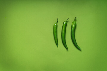green monochrome with three green peppers on a background