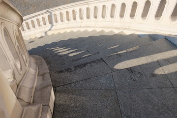 Ancient stone twisted staircase leading down. Large staircase with beautiful stone railings.
