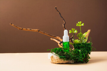 Green cosmetic product bottle with natural materials on brown and beige background