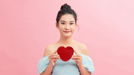 Heart. Love symbol. Portrait of beautiful woman hold Valentine day symbol. Isolated studio background female model. Beautiful girl.