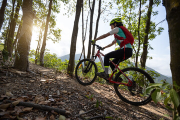 Obraz na płótnie Canvas Woman cyclist cycling on mountain top forest trail