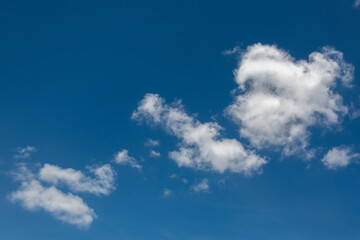 Naklejka na ściany i meble White fluffy clouds against a blue summer sky