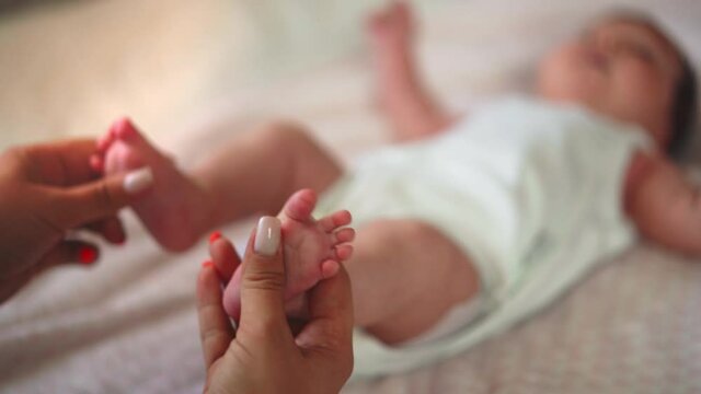 Mom gives massage to her baby.