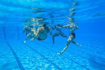 Synchronized Swimming Girls Team Unrecognizable Dance Underwater photography closeup action in blue...