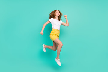 Fototapeta na wymiar Full length body size photo schoolgirl jumping up running for sale isolated vibrant teal color background